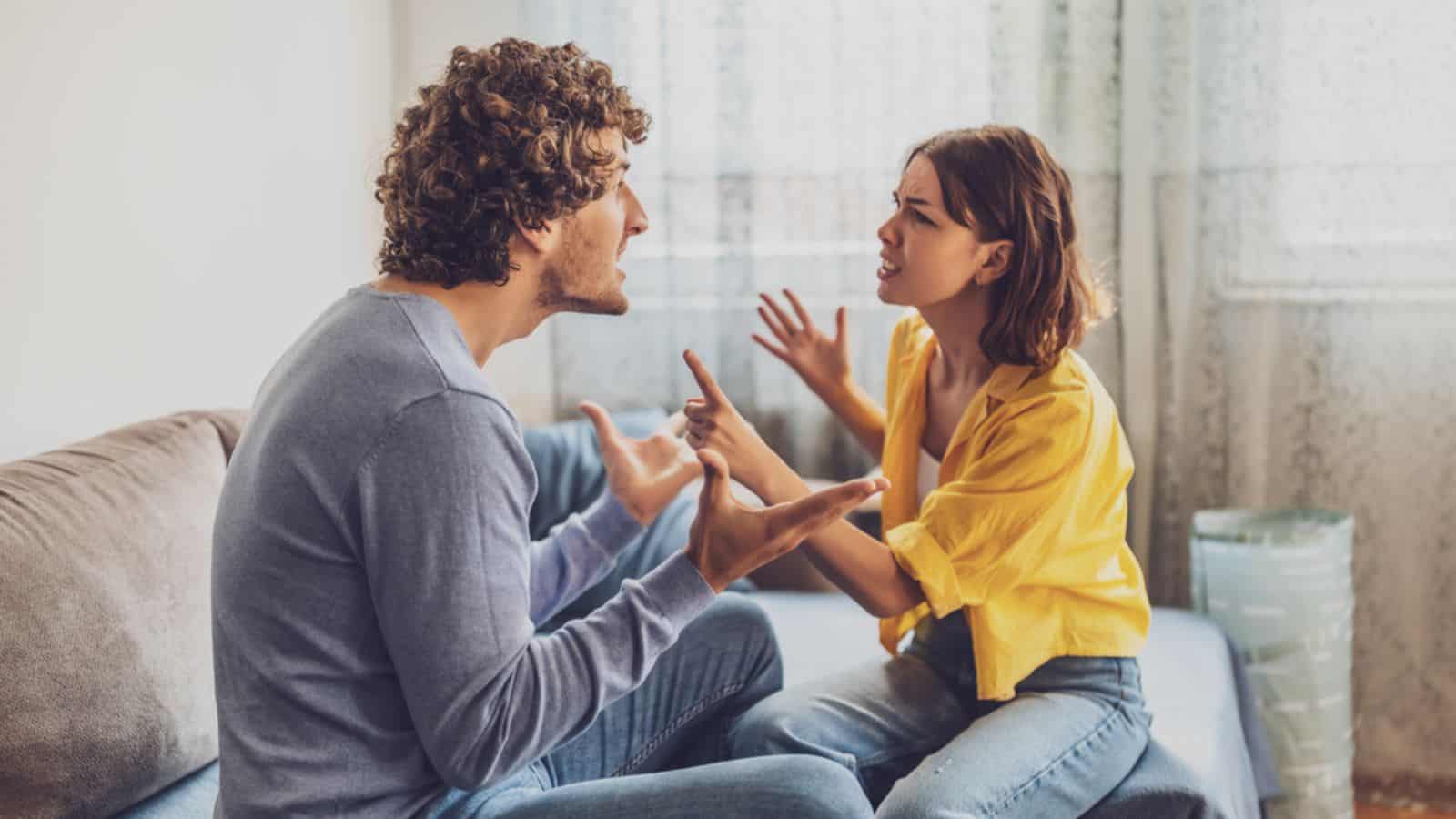 Angry couple sitting at sofa