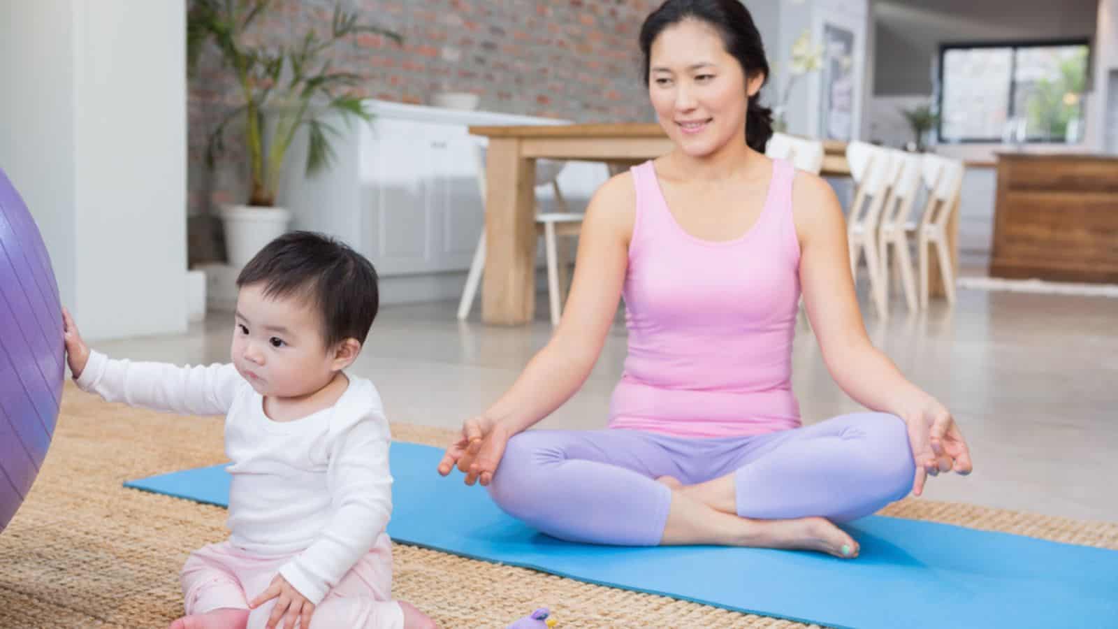 Calm mother sitting on mat at home