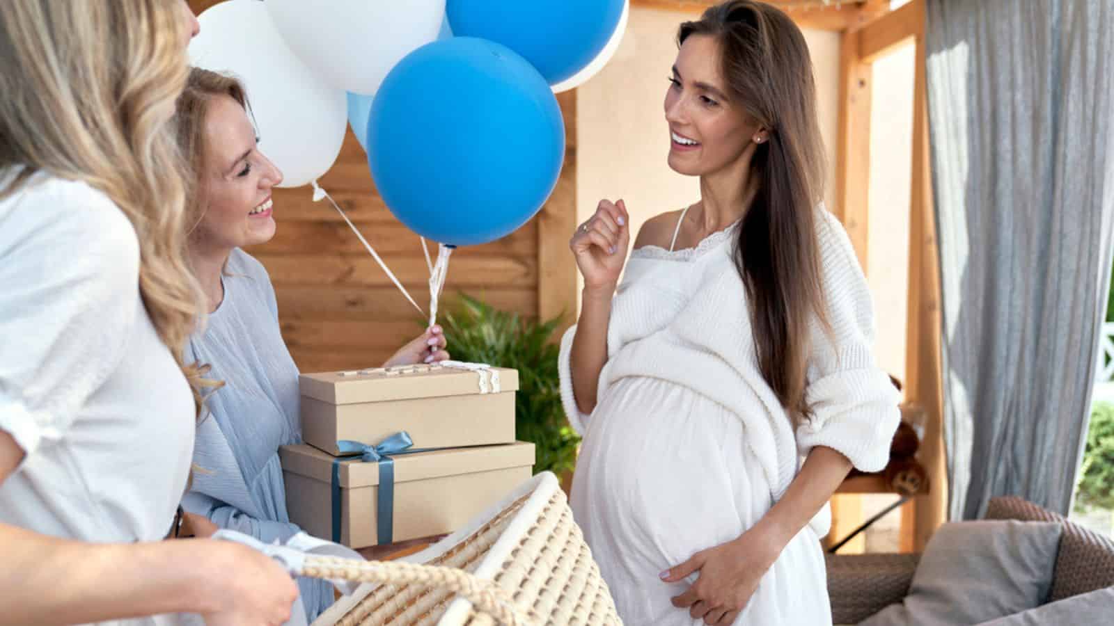 Group of caucasian women giving gifts to friend in pregnant