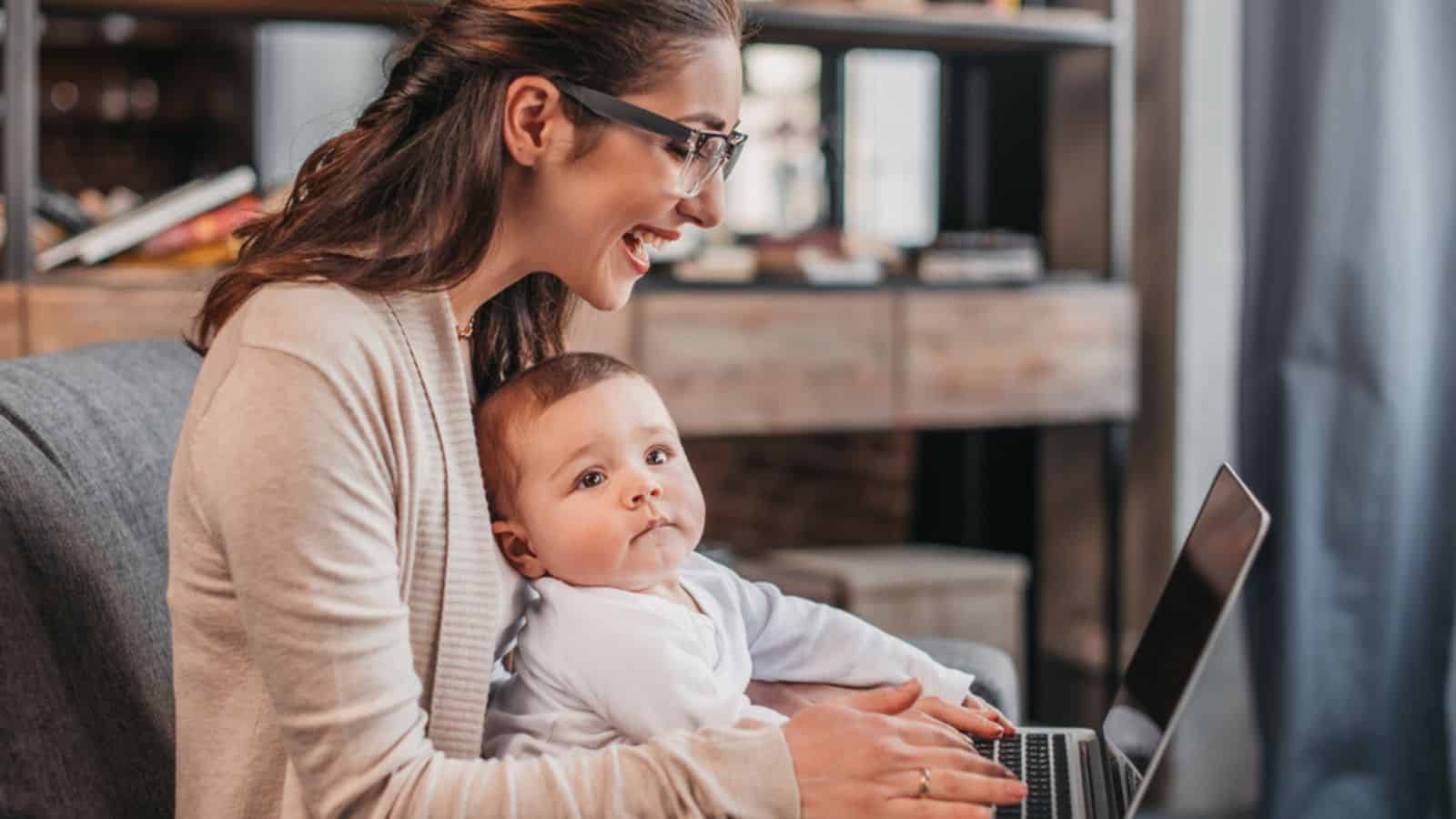 Mother with her son using laptop working at home