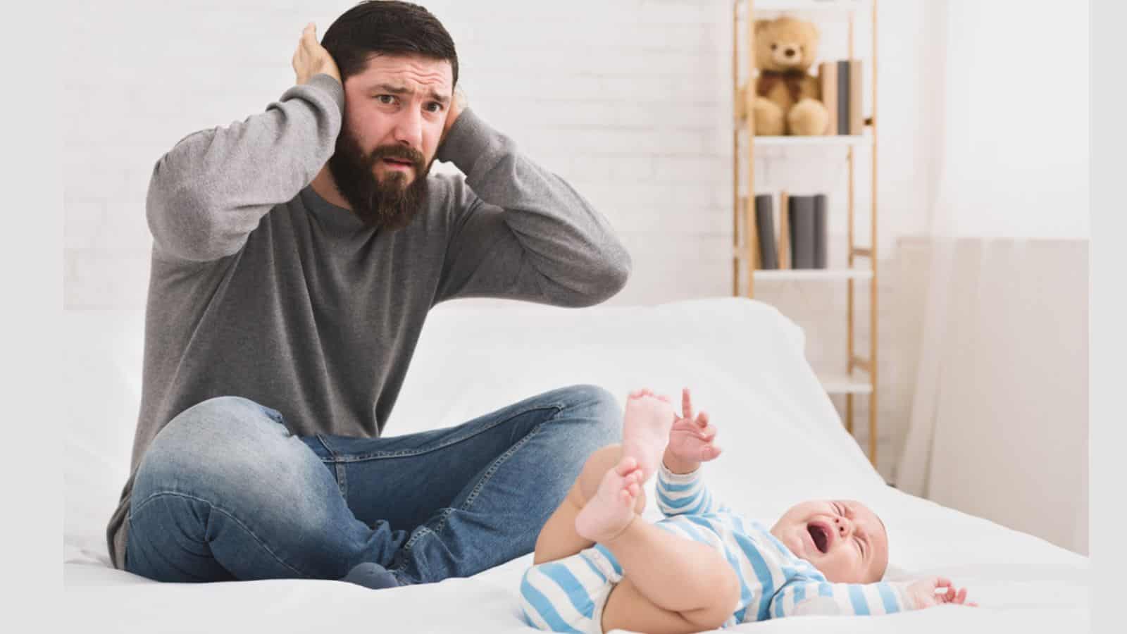 Stressed dad with a crying newborn