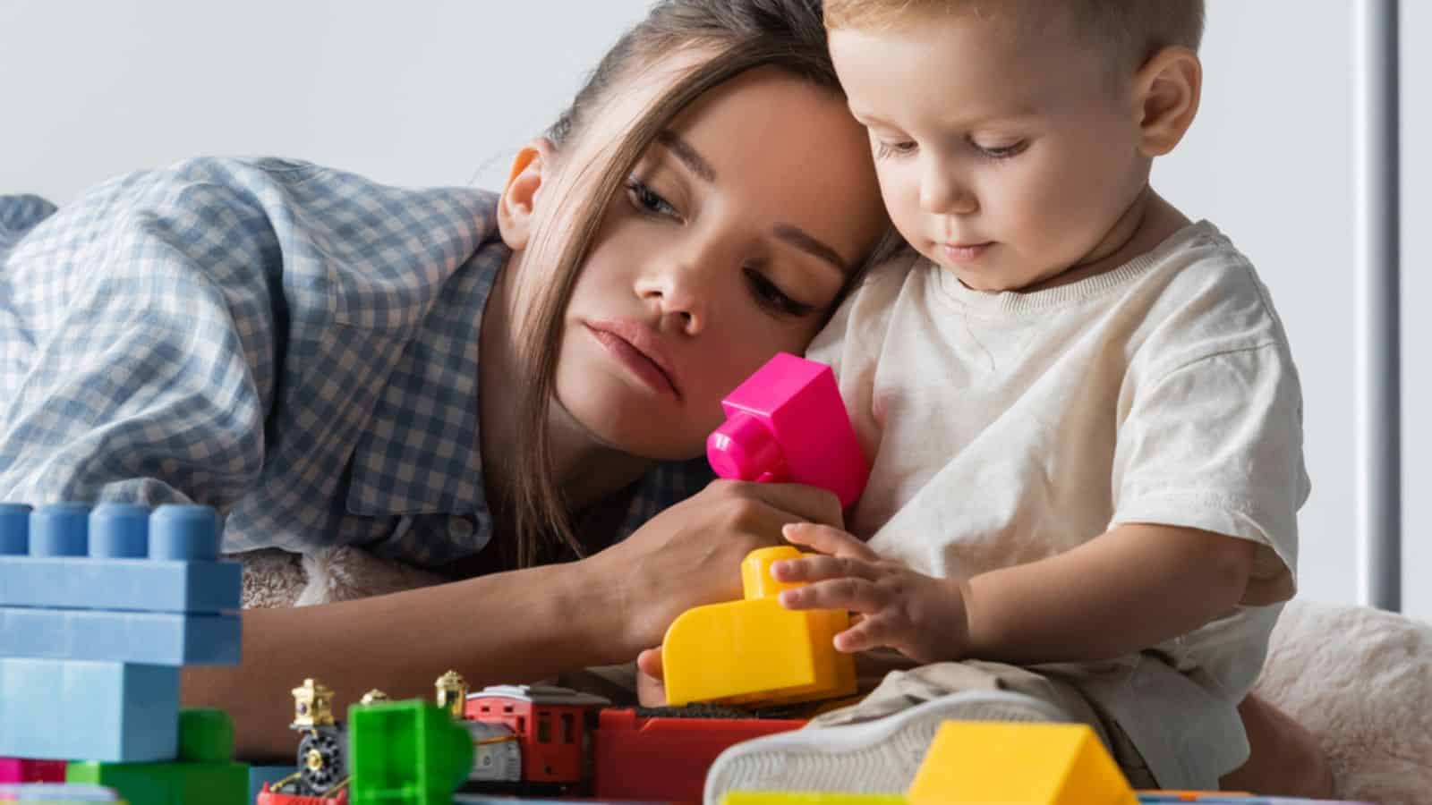 tired mom with baby legos duplo blocks