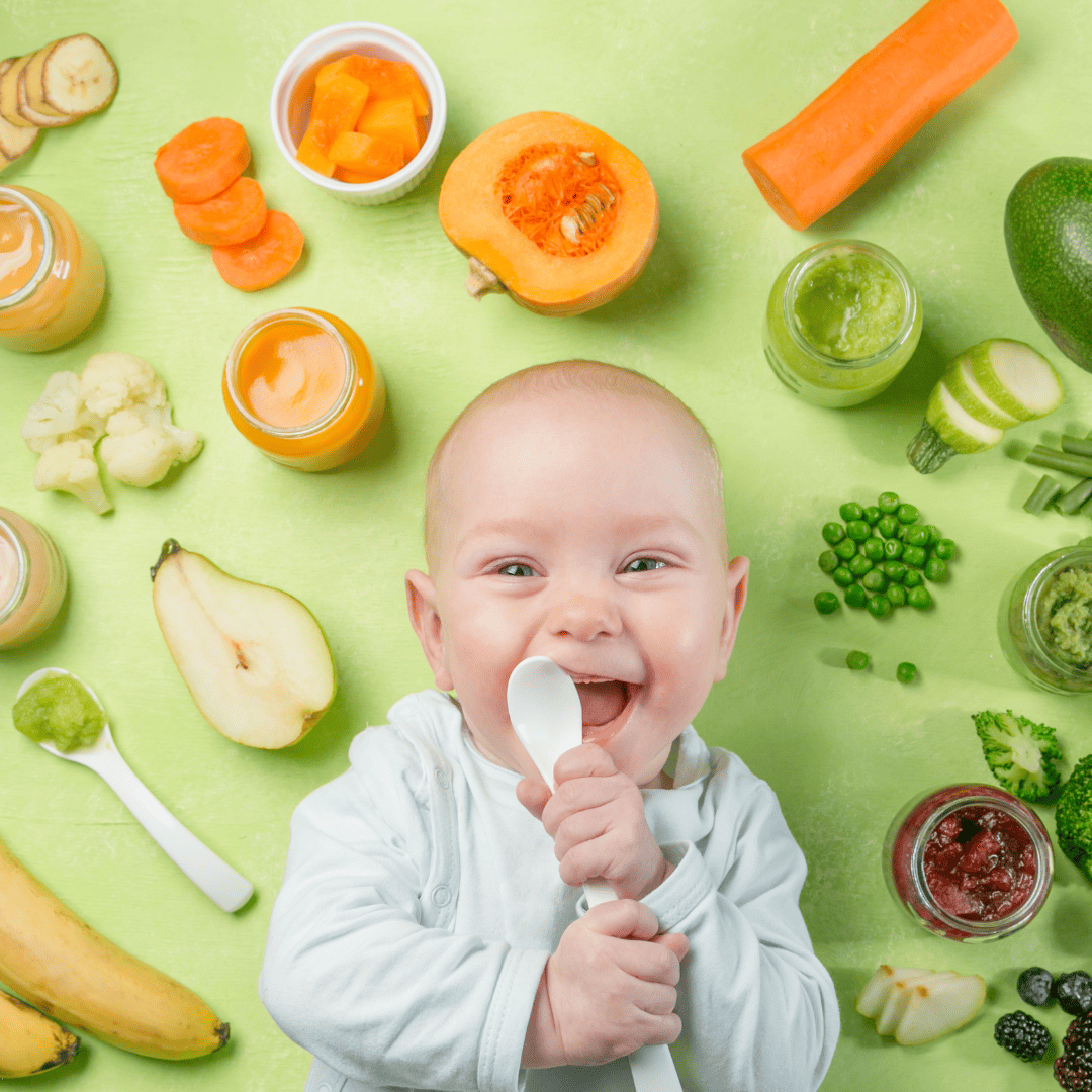 baby holding a spoon to his mouth