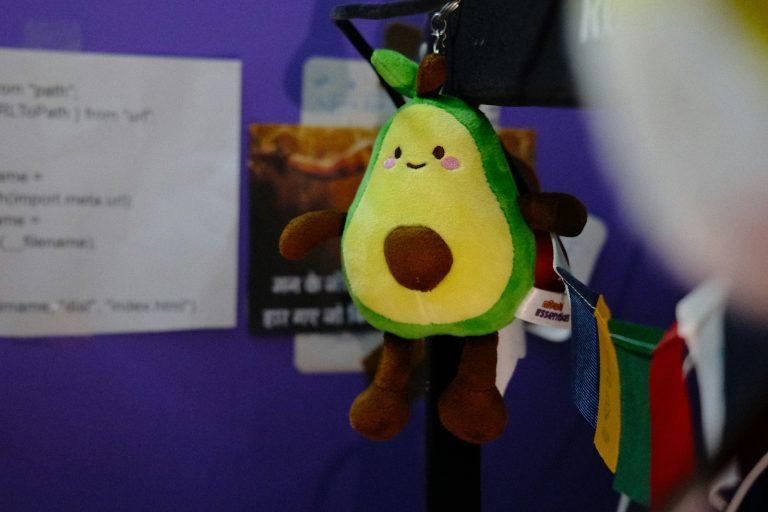 A plush avocado keychain with a smiling face; backpack charms
