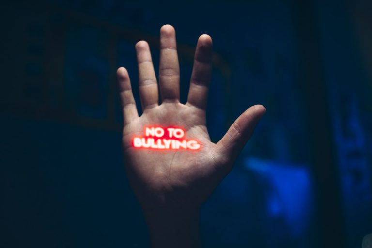 a hand with the word no to bullying written on it; signs of bullying