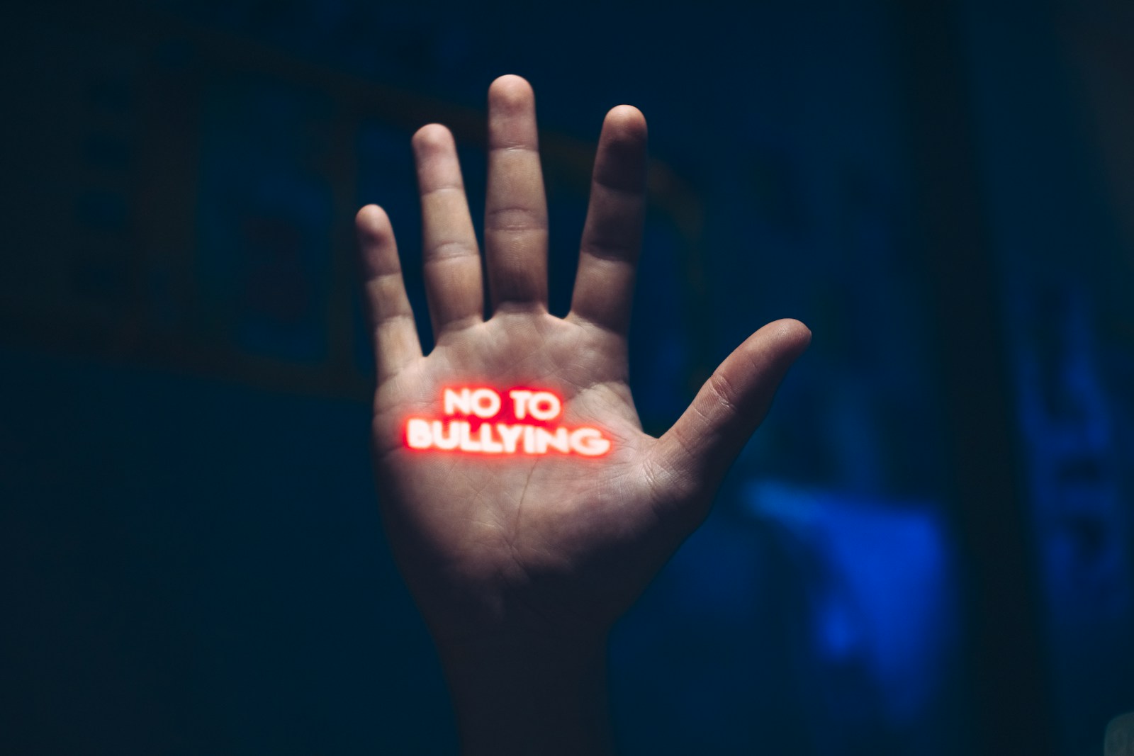 a hand with the word no to bullying written on it; signs of bullying
