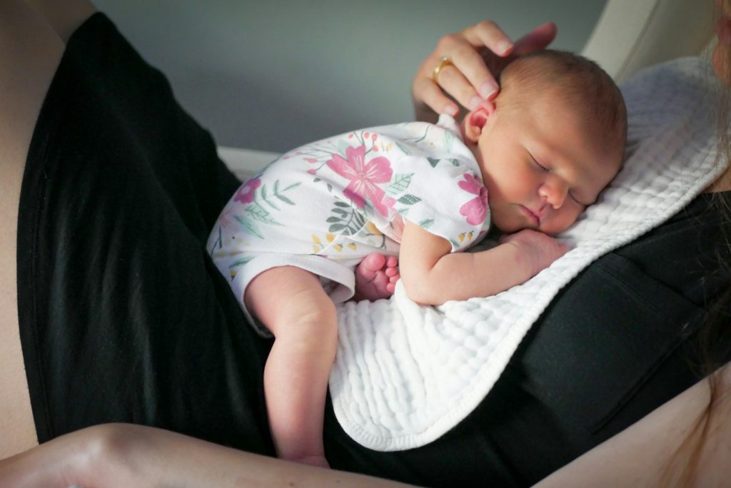 a woman holding a baby in her arms; breastfeeding