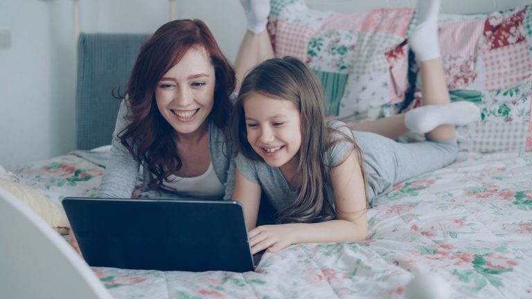 Mother and daughter laugh while using a laptop. what is echolalia