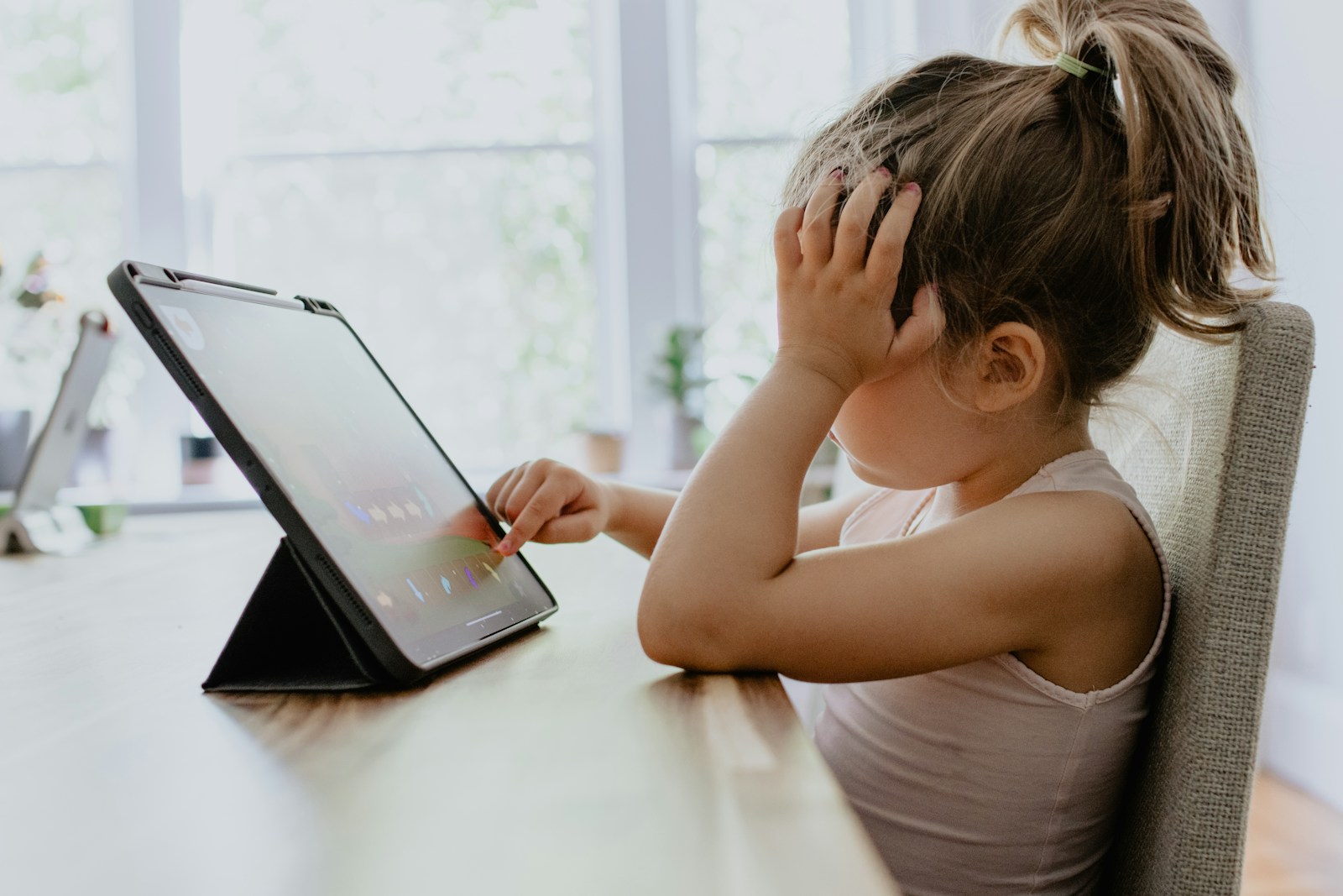 girl in white tank top using black tablet computer; screen-free fall bucket list