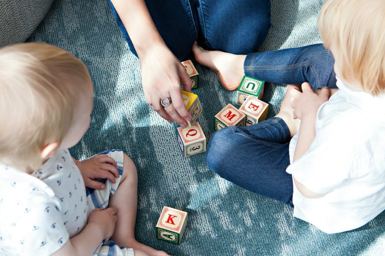 two toddler playing letter cubes; child care