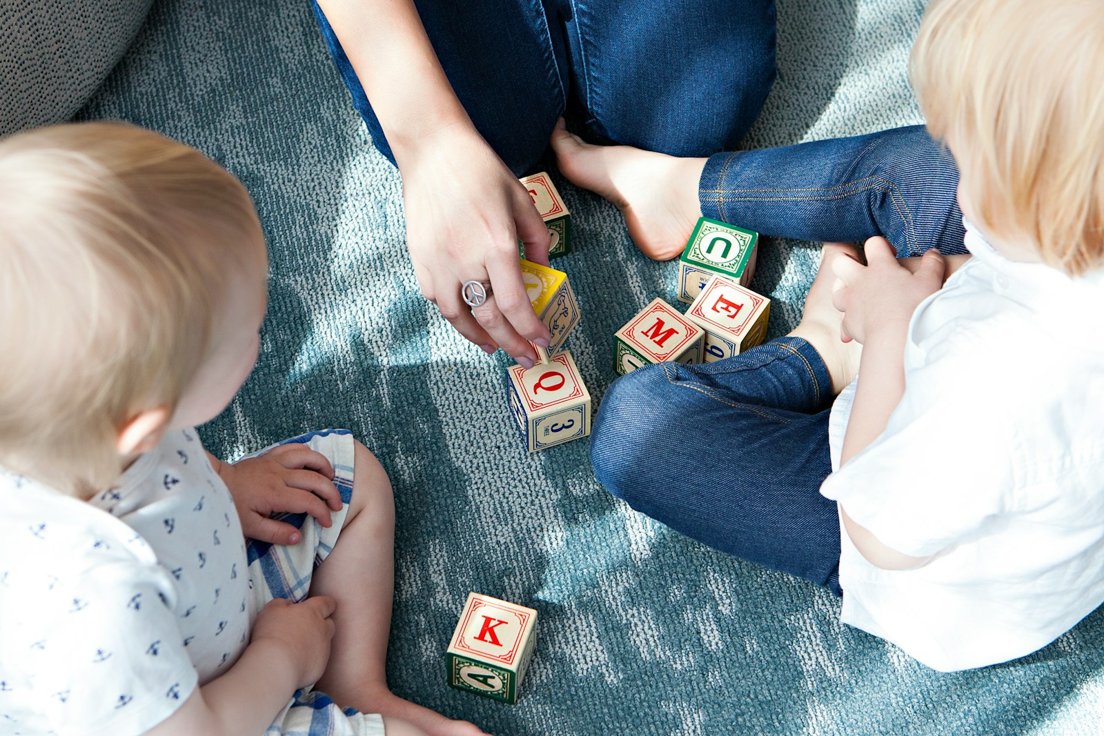two toddler playing letter cubes; child care