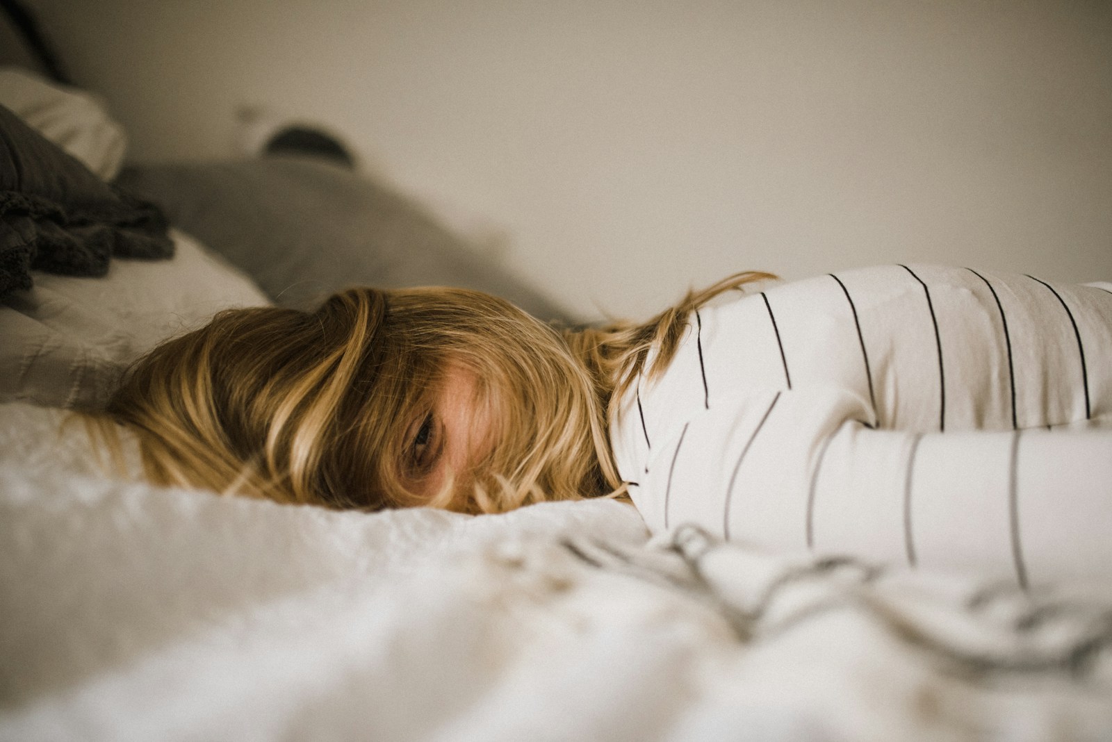 woman lying on bed; mom burnout