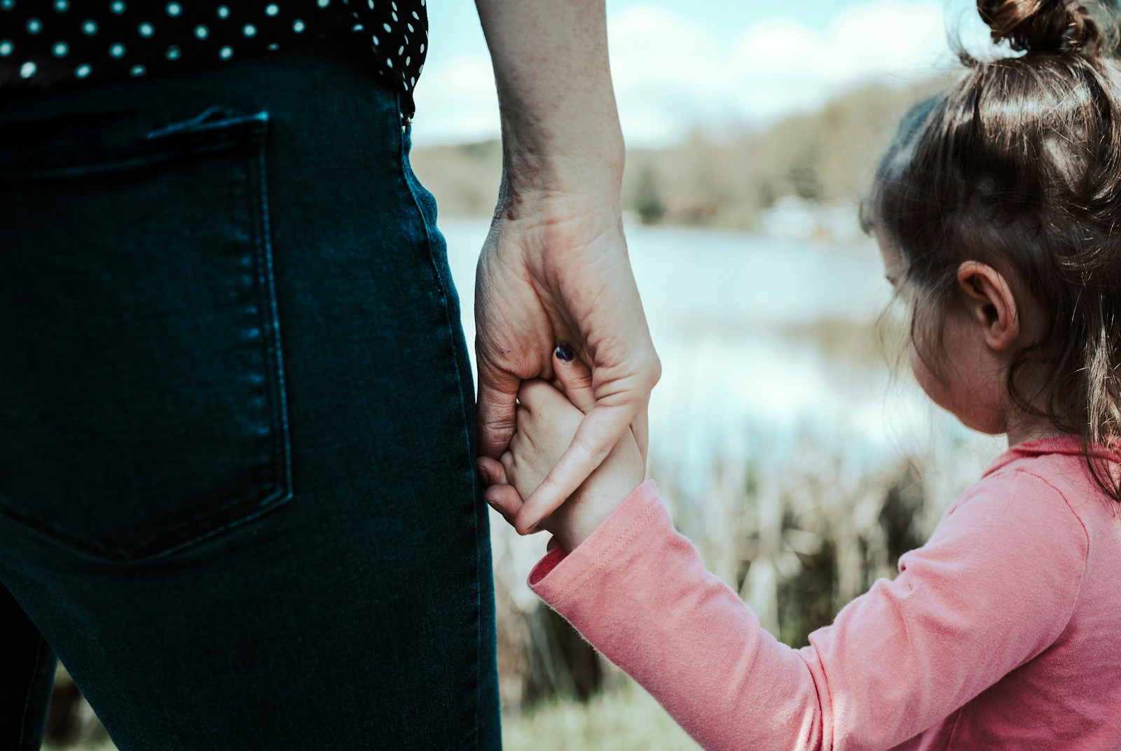 girl in pink jacket holding her hair; mom guilt