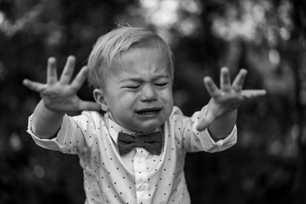grayscale photo of girl in polka dot long sleeve shirt; toddler tantrums