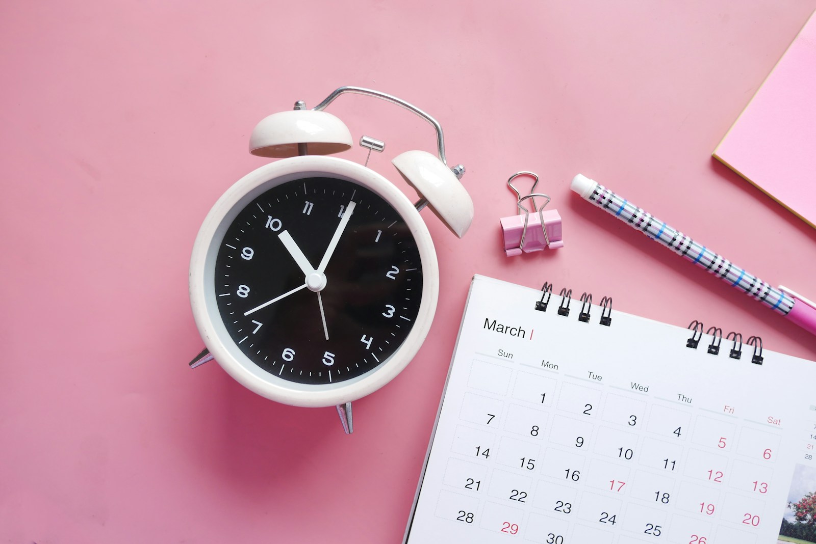 white and pink analog alarm clock; daylight saving time