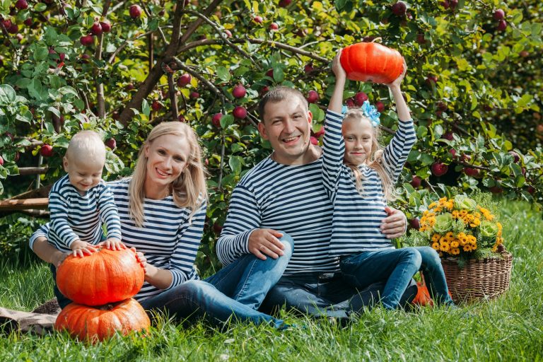 a family sitting on a bench; family Halloween costumes