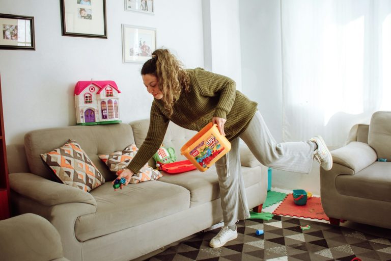 a person holding a box and a child on a couch; underconsumption core parenting