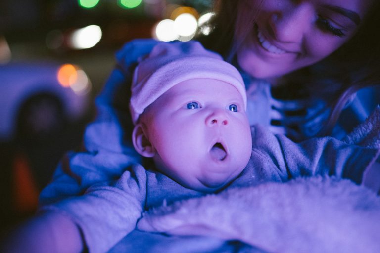 selective focus photography of woman holding baby; newborn out in public