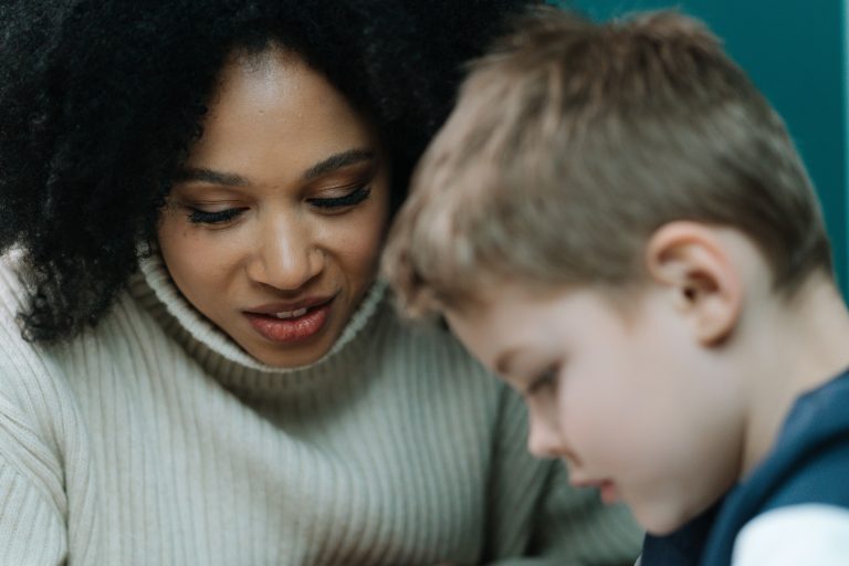 Mother talking patiently with her young son who is working through a stutter