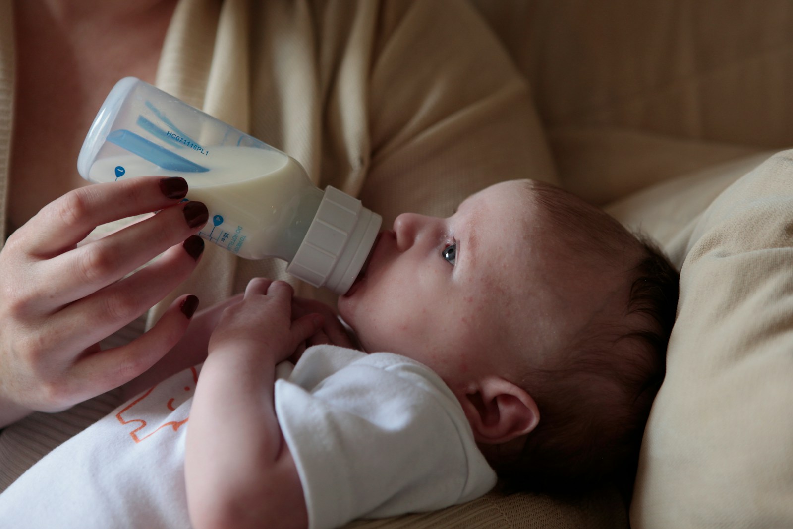 a woman feeding a baby with a bottle of milk; fed is best