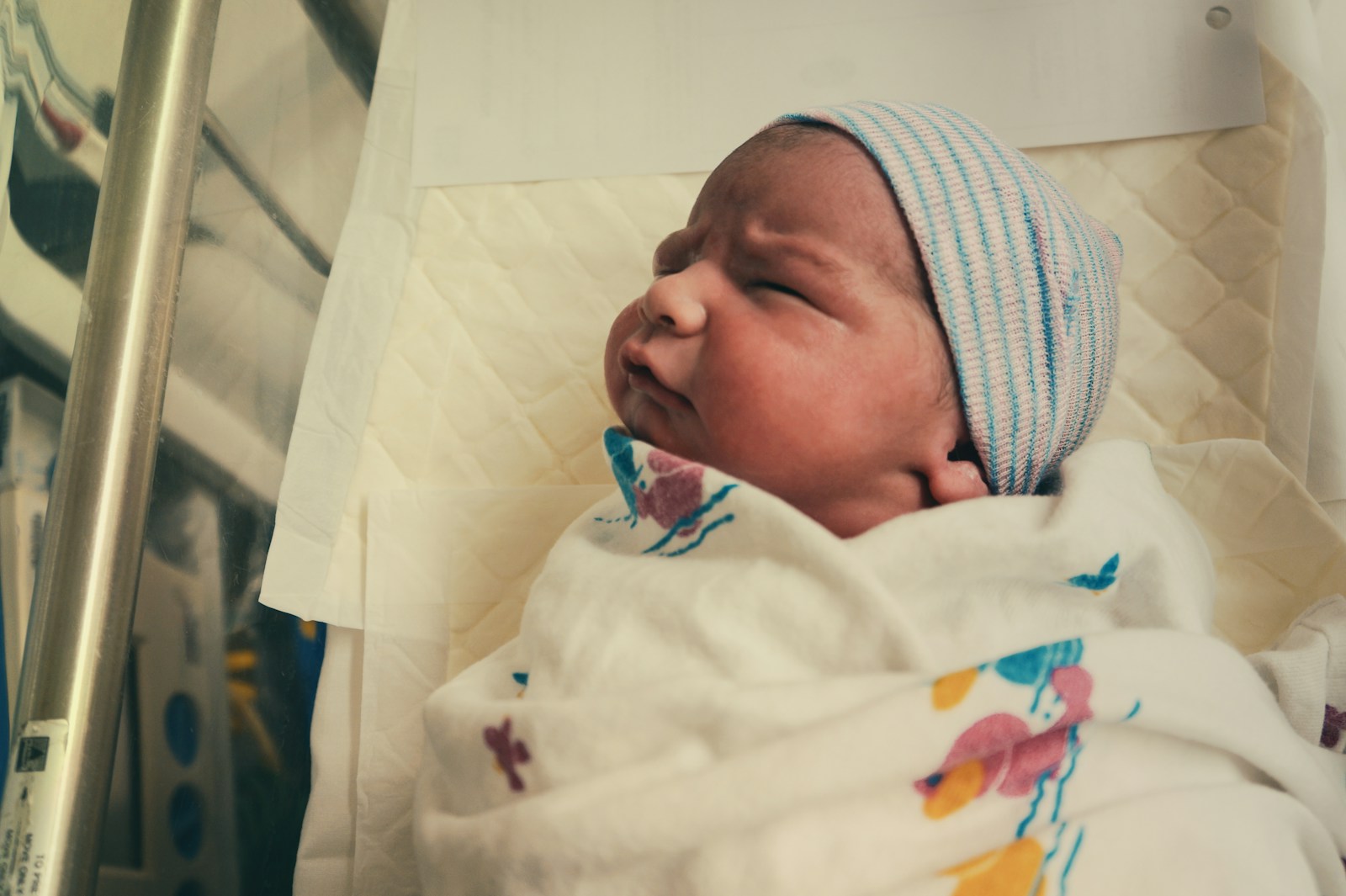 baby in white knit cap; newborn sleep schedule
