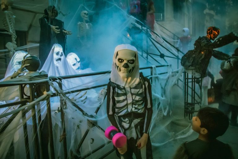 person in white mask standing beside white robot; halloween anxiety in kids